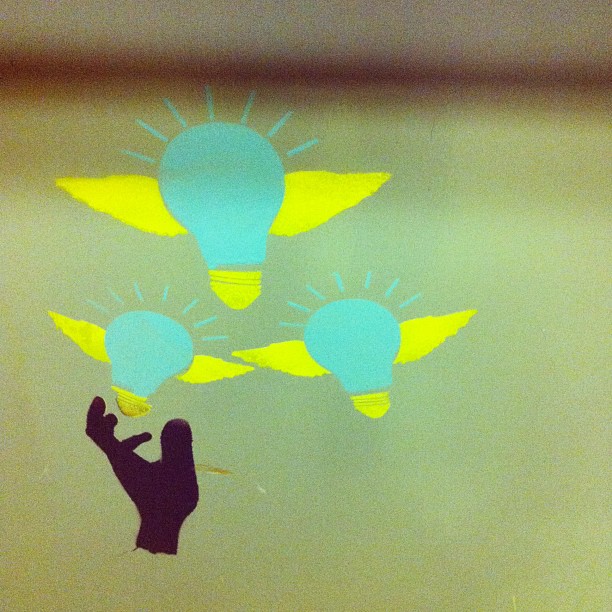 An image of a hand, reaching for light bulbs, art from the Contact building